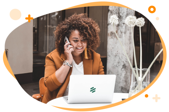 Vrouw de achter een laptop zit met een myparcel logo. Ze zit aan een tafel en is aan het bellen.