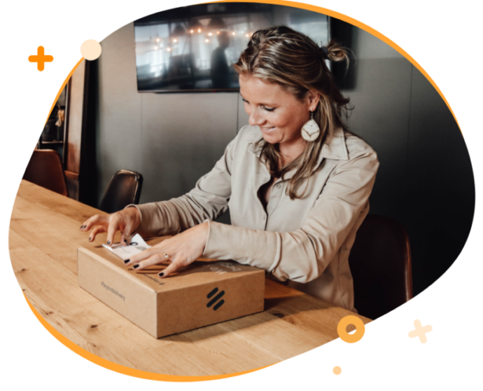 Vrouw plakt een verzendlabel op het pakket die is uitgeprint via MyParcel.